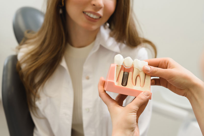 Dental Patient Getting Shown A Dental Implant Model During Her Consultation in Allen, TX